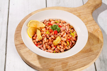 Colorful Cold Peanut Rice Noodle Salad with Vegetables and Lemon Garnish on Wooden Board
