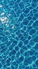 Obraz premium Sunlight dances on the surface of clear, blue water, creating a shimmering, rippling pattern.