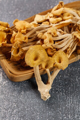 Fototapeta premium Dried Golden Chanterelle Mushrooms from Yunnan China in Wooden Basket on Stone Surface