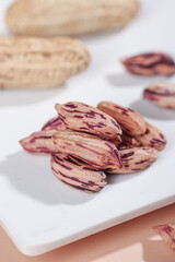 Colorful Red Striped Peanuts on White Marble - Fresh Homegrown Legumes for Healthy Nutrition