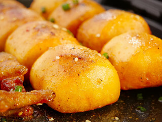 Golden baked dinner buns with herbs and bacon in cast iron skillet