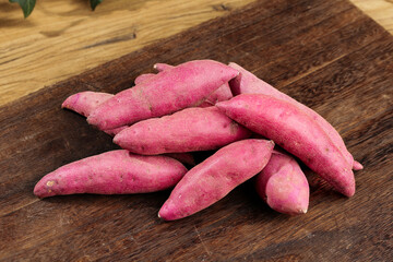 Fresh Purple Sweet Potatoes on Wooden Cutting Board - Healthy Organic Root Vegetables