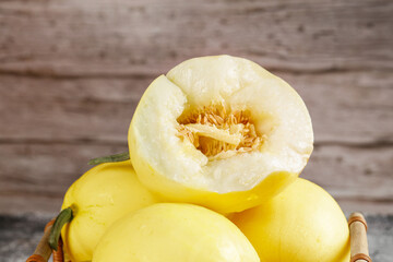 Fresh Sweet Yellow Melons Cut in Half Showing Seeds and Flesh in Wooden Basket