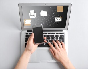 Overhead view of hands using laptop and phone, displaying data network icons