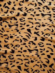 The pattern and background of the yellow fabric with black dots resembles leopard skin.