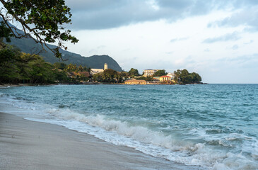 Anse Beau Vallon tropical beach in cloudy weather, ocean waves out of season on Mahe island