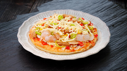 Fresh baked Italian pizza with cheese, mushrooms and colorful vegetables on wooden table