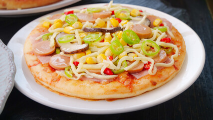 Delicious cheesy Italian pizza with mushrooms corn and peppers - fresh grilled cuisine on white plate