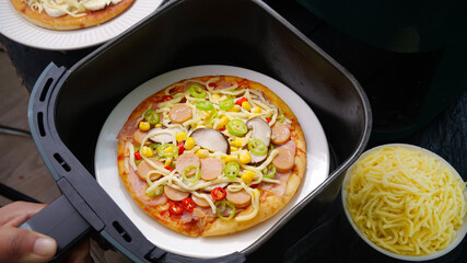 Grilled Italian Pizza with Sausage and Vegetables Cooking in Air Fryer Basket