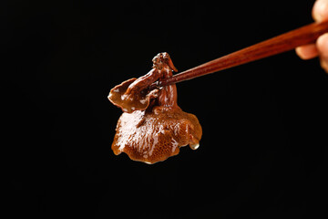 Cooked Porcini Mushroom with Chopsticks Hot Pot Ingredient on Black Background
