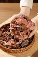 Yunnan Dried Porcini Mushrooms in Hands with Basket Collection - Premium Cooking Ingredients for Hot Pot Recipes