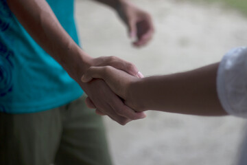 Two people shaking hands in a closeup outdoor shot
