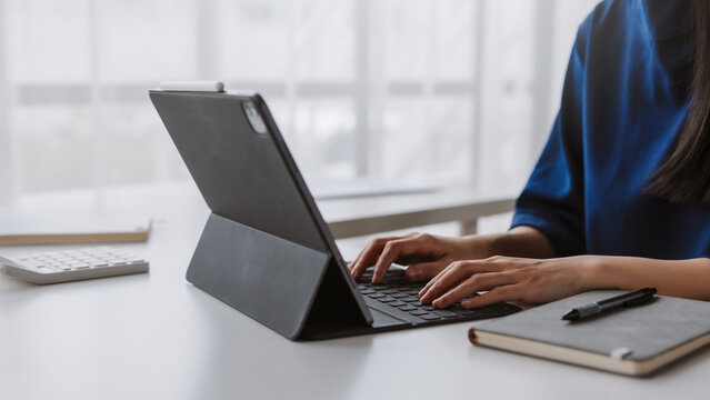Woman typing on tablet keyboard working remotely