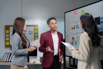 Business team collaborating discussing charts data in office