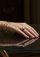 Elegant hand showcasing diamond ring and golden bracelets on reflective surface