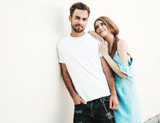 Portrait of smiling beautiful woman and her handsome boyfriend. Woman in casual summer jeans dress. Happy cheerful family. Female having fun. Couple posing on the street background