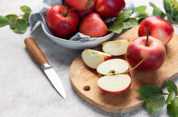 Red apples, whole and sliced, on cutting board