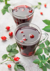 Drinking hot rosehip tea with berries and leaves
