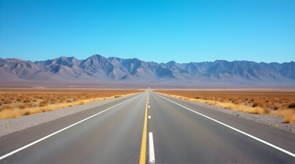 Endless highway stretching towards distant mountains symbolizing freedom and adventure under a clear
