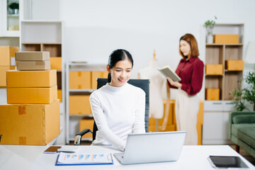 Starting small businesses SME owners, two check online orders Selling products working with boxs...