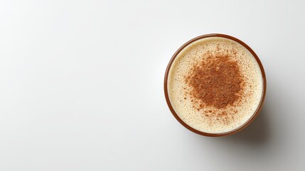 Top view of creamy drink with cinnamon powder in glass on white background