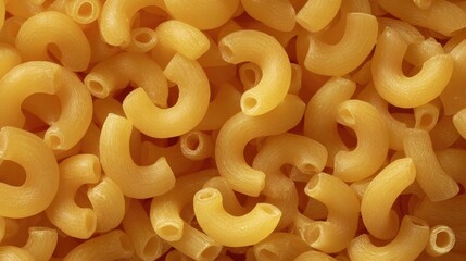 Close-up full frame of dry elbow macaroni pasta, forming a seamless background texture.