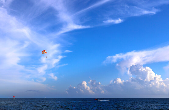 Picturesque view of sea and tourists on a parachute. Topic of summer vacation, travel, leisure and adventure for tourist. Parasailing in the sea. A popular tourist pastime with a parascending
