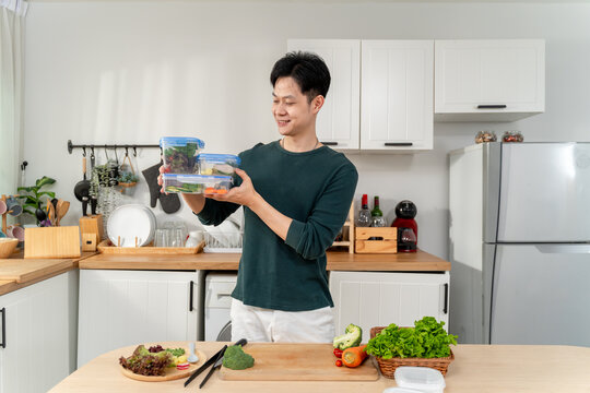 Asian young man cooking healthy foods in kitchen in morning at home.