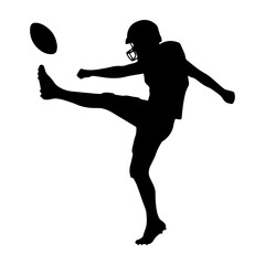 Silhouette of an American football player kicking a ball
