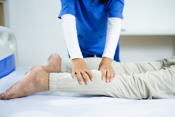 Fototapeta premium Nurse or therapist assists senior man with leg stretch therapy. Ideal for physiotherapy, injury recovery, elder care, wellness, and chronic pain treatment stock concepts.