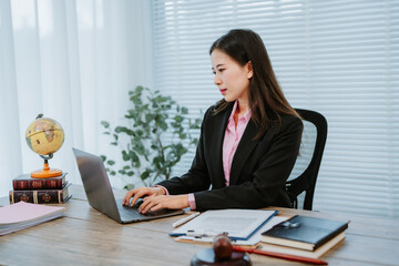 Focused businesswoman working with documents and a computer in a modern office