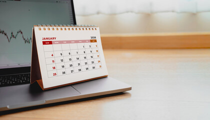 Close-up photo of a January 2026 desk calendar placed on a laptop. Illustrating business planning for the new year.