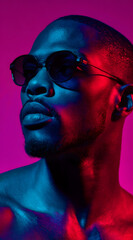 fashion portrait of model wearing sunglasses with vibrant pink and blue lighting creating sharp contrast on skin texture