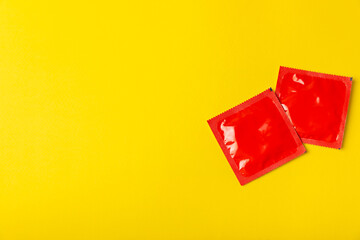 Condoms on a colored background. Colorful fruit-themed condoms in packaging. Safe sex concept....