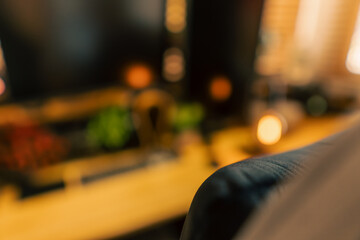 Cozy vintage desk setup featuring warm lighting, monitor, keyboard, gaming chair and gadgets in a studio workspace. Perfect background for productivity, lifestyle and workstation themes.