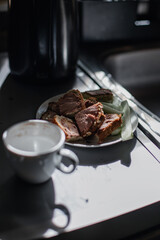 Country lunch - rolls with pate and cucumber on which the sunlight shines, piled on a plate with a metal sink.