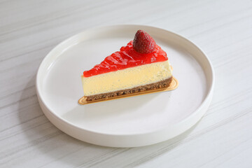 Delicious Slice of Strawberry Cheesecake with Glaze on White Plate