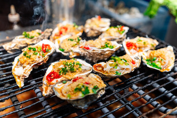 Grilled oysters traditional street food at local market in Chengdu, China