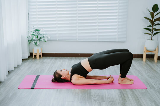Woman practicing triangle yoga pose at home during quarantine
