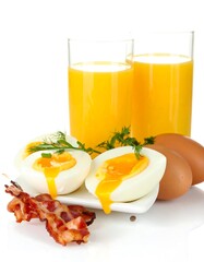 Hard-boiled eggs, bacon, and orange juice on a white background