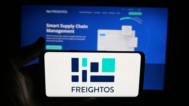 Stuttgart, Germany - 09-25-2025: Person holding cellphone with logo of freight booking company Freightos Ltd. on screen in front of webpage. Focus on phone display.