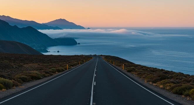Open road perspective towards ocean horizon with scenic mountains under dusk sky and copy space