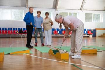 elderly group  plays mini golf for competitions in the sprot hall.  Kidult gaming in the gym....