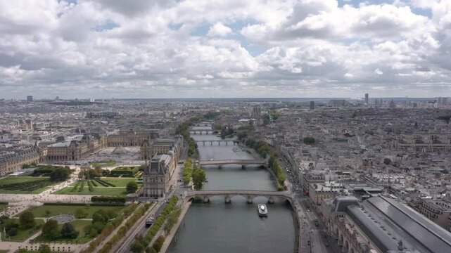 Stunning aerial flying over the Seine River showcasing the Louvre, Tuileries Garden, and Musee d'Orsay surrounded by the historic Parisian skyline.