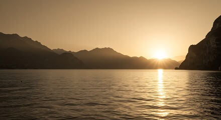 Tranquil mountain lake landscape with setting sun and atmospheric light