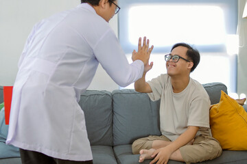 Obraz premium Joyful Doctor Gives High Five to Smiling Patient with Down Syndrome Celebrating Progress