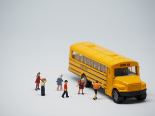 Mini toy of action figure and mini car at table. Background is blurred. First day school concept design. Back to School concept with yellow school bus.