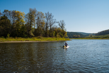 Fototapeta premium Enjoy a Serene and Wonderful Kayaking Experience on a Calm River, Completely Surrounded by Gorgeous Lush Autumn Foliage and Vibrant Colors, While Embracing the Beauty of Natures Bounty