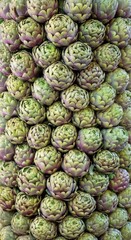 Obraz premium Vibrant Stacked Fresh Artichokes Close-Up: A Healthy Produce Background for Food Marketing