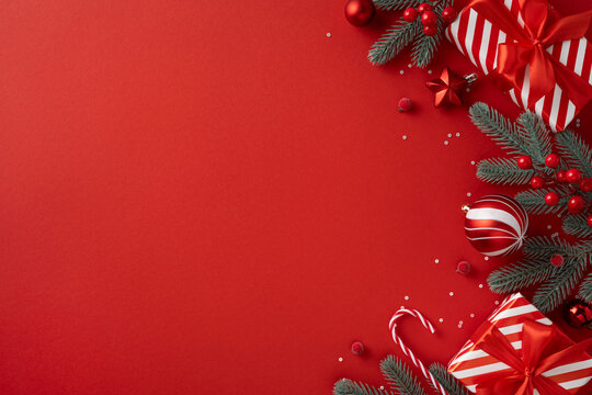 Vibrant red holiday scene featuring pine branches, red ornaments, candy canes, and striped gifts ready for Christmas and New Year greetings